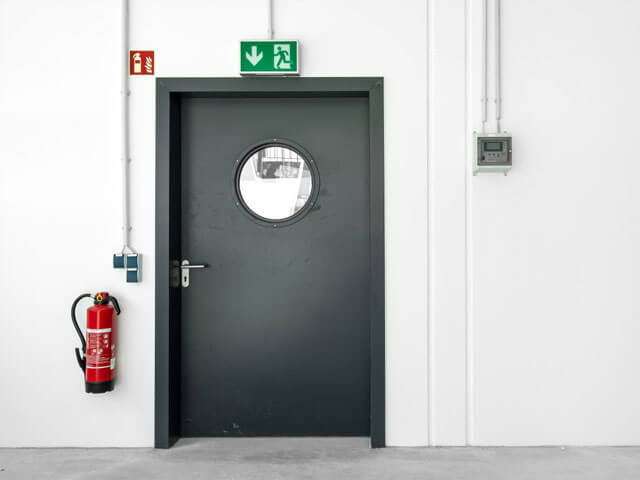 Brandschutz (© adobe stock "Fluchtweg Tür Notausgang"  von MATTHIAS BUEHNER) Branschutz mit Feuerlöscher und Brandschutztür